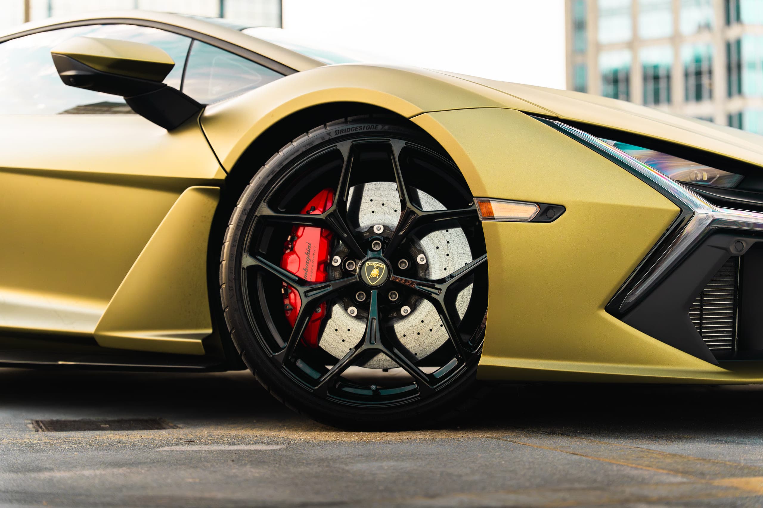 Close detail of a sports car wheel and red brake caliper